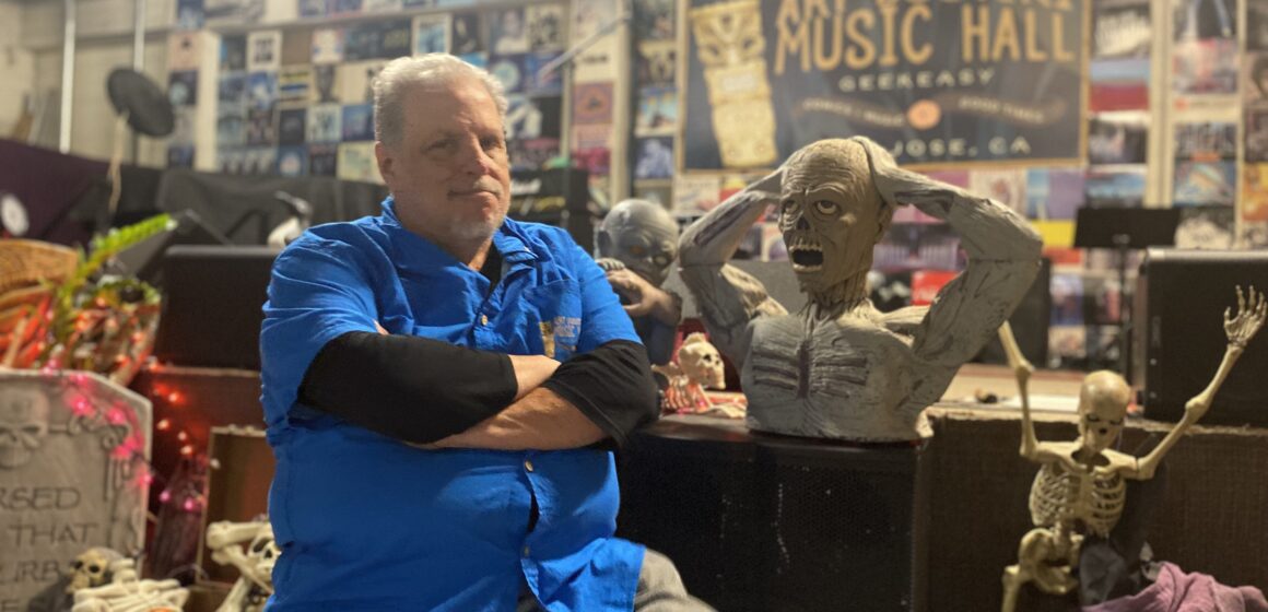 A man in a blue shirt standing inside a live music venue in San Jose, California