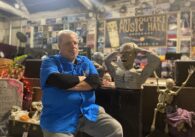 A man in a blue shirt standing inside a live music venue in San Jose, California