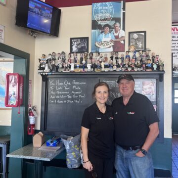 SNAP PIZZA A man and a woman stand in front of a chalk board inside a pizza restaurant in San Jose, California