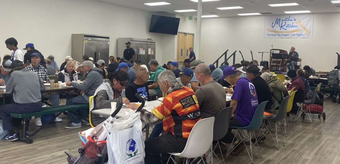 MARTHA'S KITCHEN People sitting at tables eating a meal provided by a food aid nonprofit