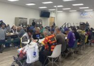 People sitting at tables eating a meal provided by a food aid nonprofit