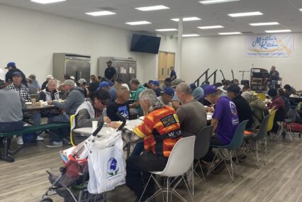 People sitting at tables eating a meal provided by a food aid nonprofit