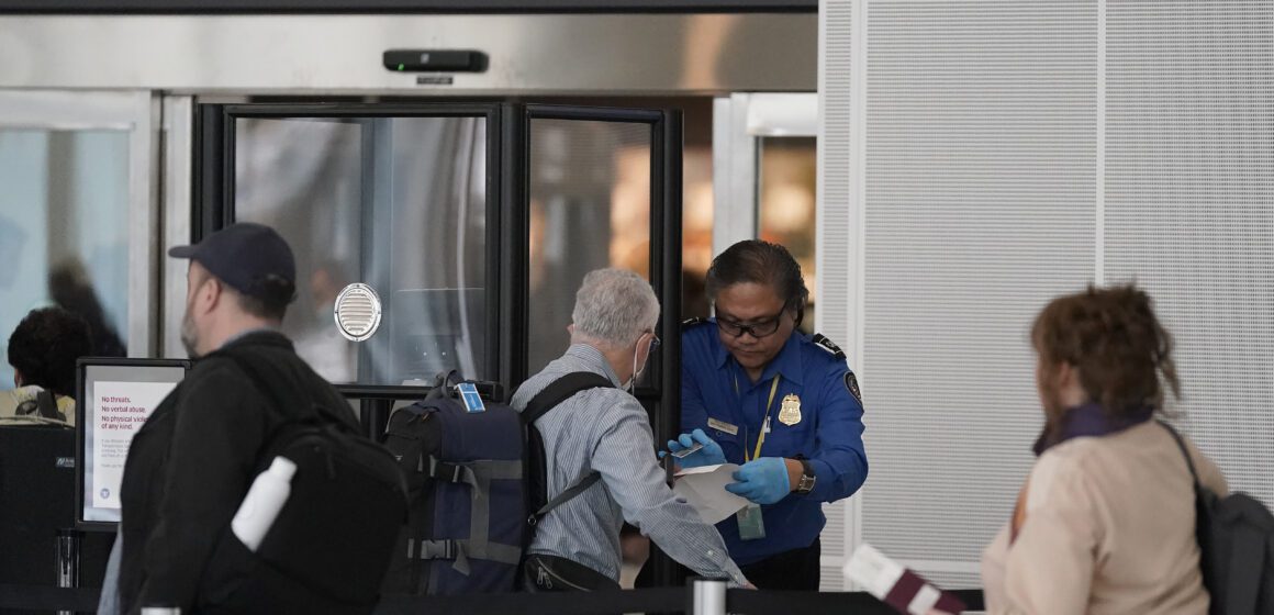 People go through a TSA checkpoint at an airport