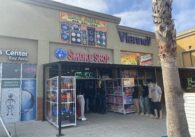 A retail storefront where the entrance is lined with toys and clothing displays.