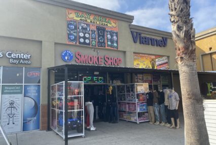 A retail storefront where the entrance is lined with toys and clothing displays.