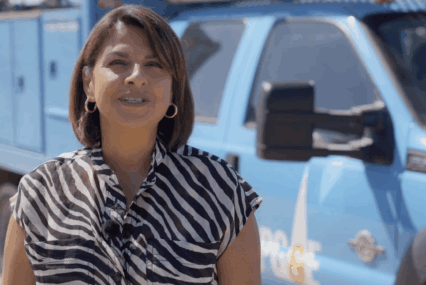 A woman standing in front of a PG&E utility truck