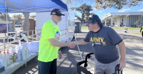 Two veterans shake hands outdoors at a resource fair in Santa Clara County, California