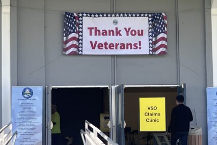 A 'thank you veterans' sign is displayed above a door at a resource fair in San Jose, California