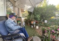 An older man sitting in a backyard
