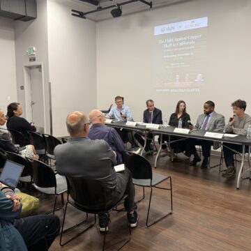 Un público observa a un panel de personas hablando en una mesa.