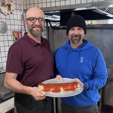 Di Maggio's Two men holding a stromboli in the kitchen of a restaurant in San Jose, California