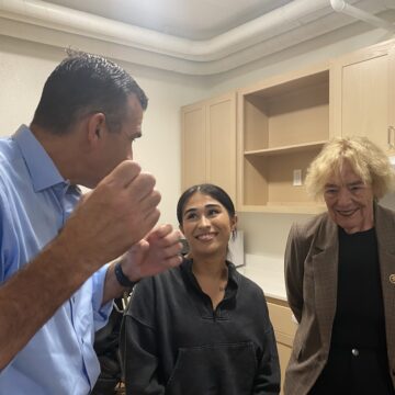 Three people stand inside an apartment in San Jose, California