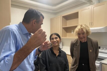 Three people stand inside an apartment in San Jose, California