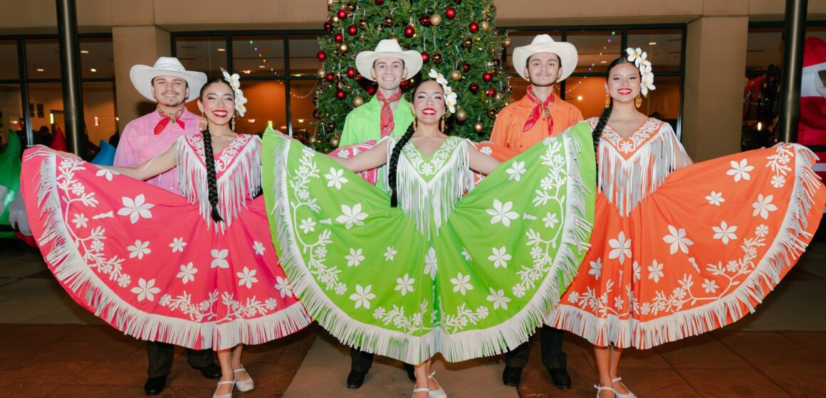 Three female dancers stand in front of three male dancers