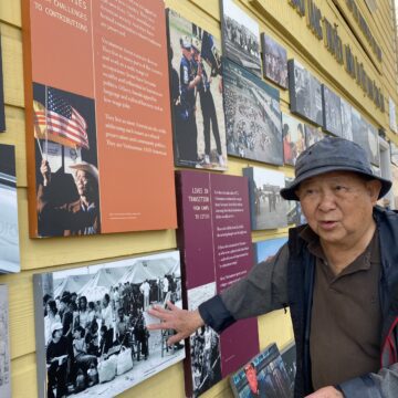 Loc Vu An older Vietnamese man in a bucket hat and coat stands next to a museum exhibit in San Jose, California