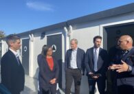 Một nhóm chính trị gia đang đứng tại một khu nhà ở dành cho người vô gia cư ở San Jose, California