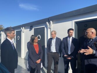 Gubernatorial tour Cherry Avenue San Jose A group of politicians standing at a homeless housing site in San Jose, California
