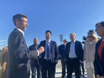 Un hombre con traje habla con personas en un complejo de viviendas para personas sin hogar en San José, California.