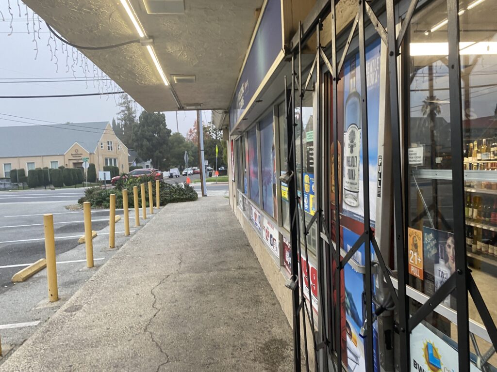 A metal gate in front of a commercial building.