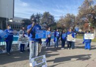 A group of nurses protesting and holding signs outside a hospital in San Jose, California