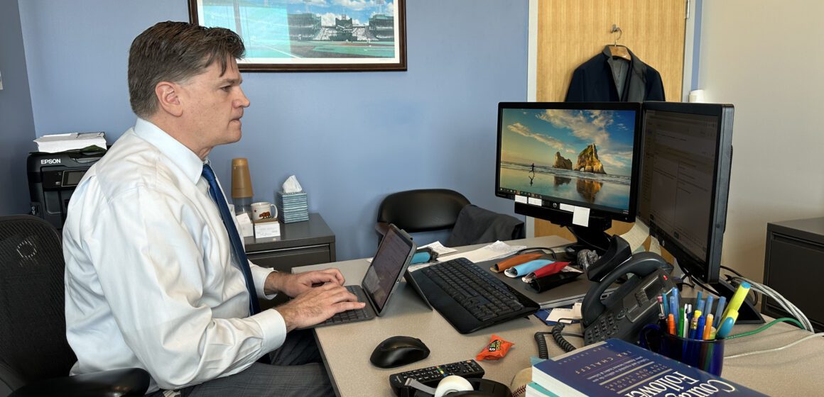 Jim Reed A man types on a keyboard at a desk in an office