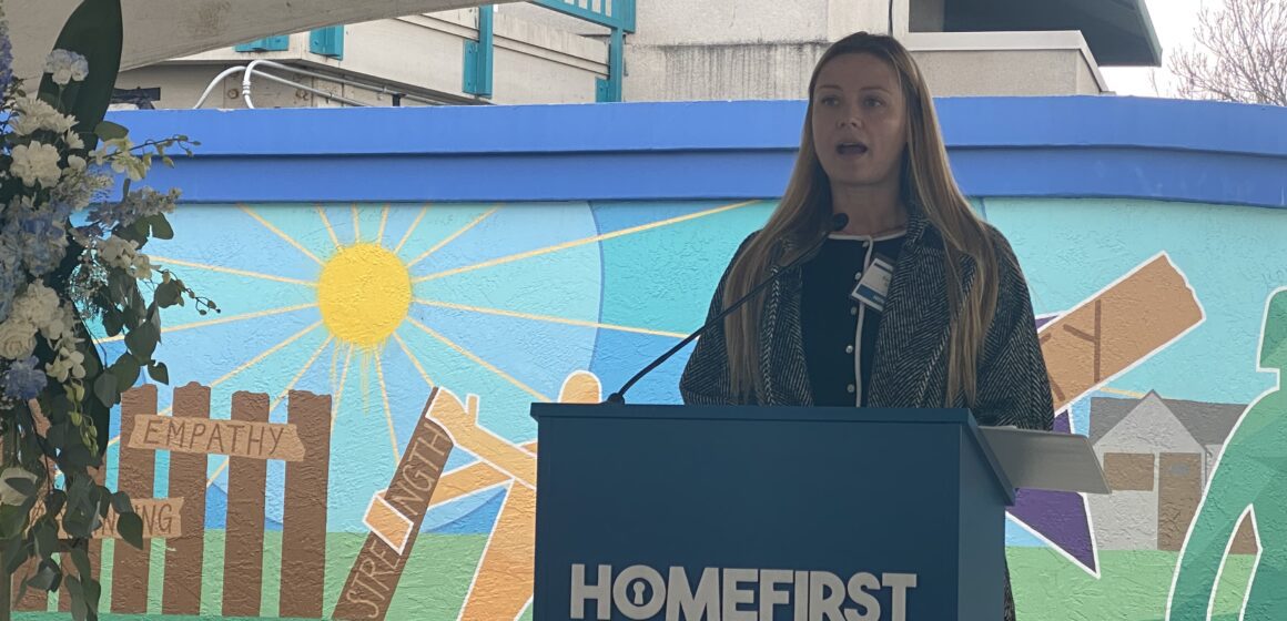 A woman speaking at a podium during a memorial for homeless people in San Jose, California