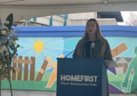 Una mujer habla en un podio durante un homenaje a las personas sin hogar en San José, California.