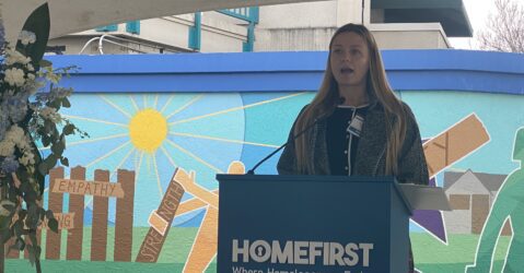 A woman speaking at a podium during a memorial for homeless people in San Jose, California