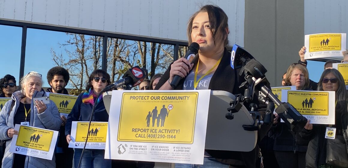 A woman speaks into a microphone at a podium in San Jose