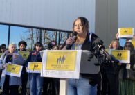 A woman speaks into a microphone at a podium in San Jose