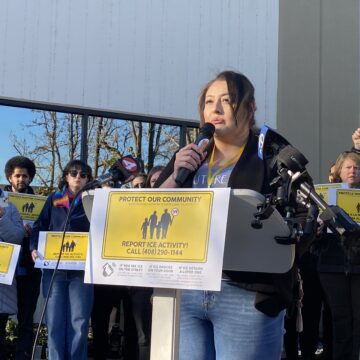 San Jose ICE -Yesenia Campos A woman speaks into a microphone at a podium in San Jose