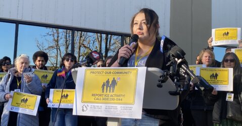 A woman speaks into a microphone at a podium in San Jose