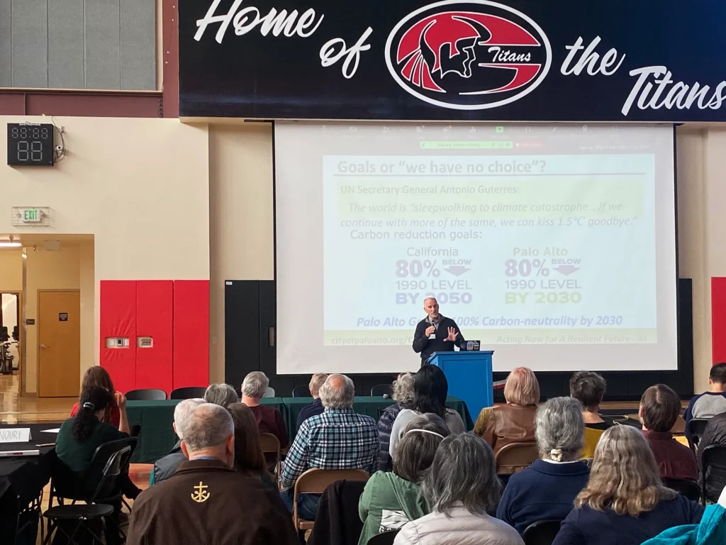 Hombre hablando con un grupo de personas en una habitación.