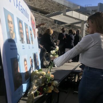 VTA Mass Shooting A woman presents flowers to a memorial poster board at a vigil.