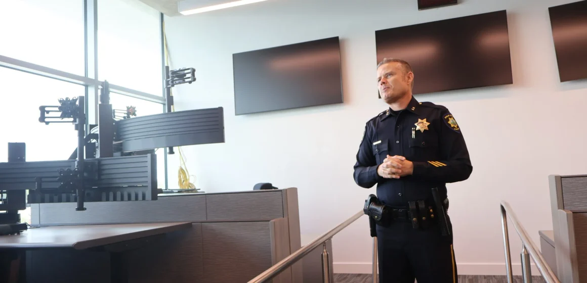 A police officer standing in a dispatch center in Palo Alto, California