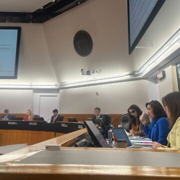 A group of people sitting behind a dais at a government meeting in Santa Clara County, California