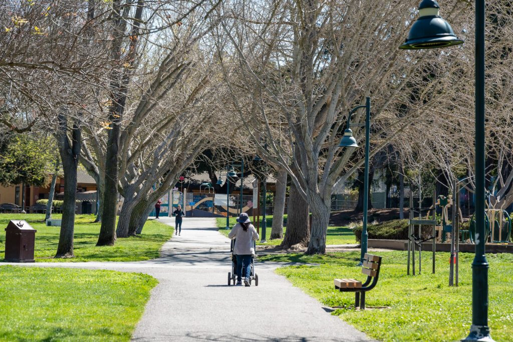 A person pushing a stroller on a path in a park in Mountain View, California