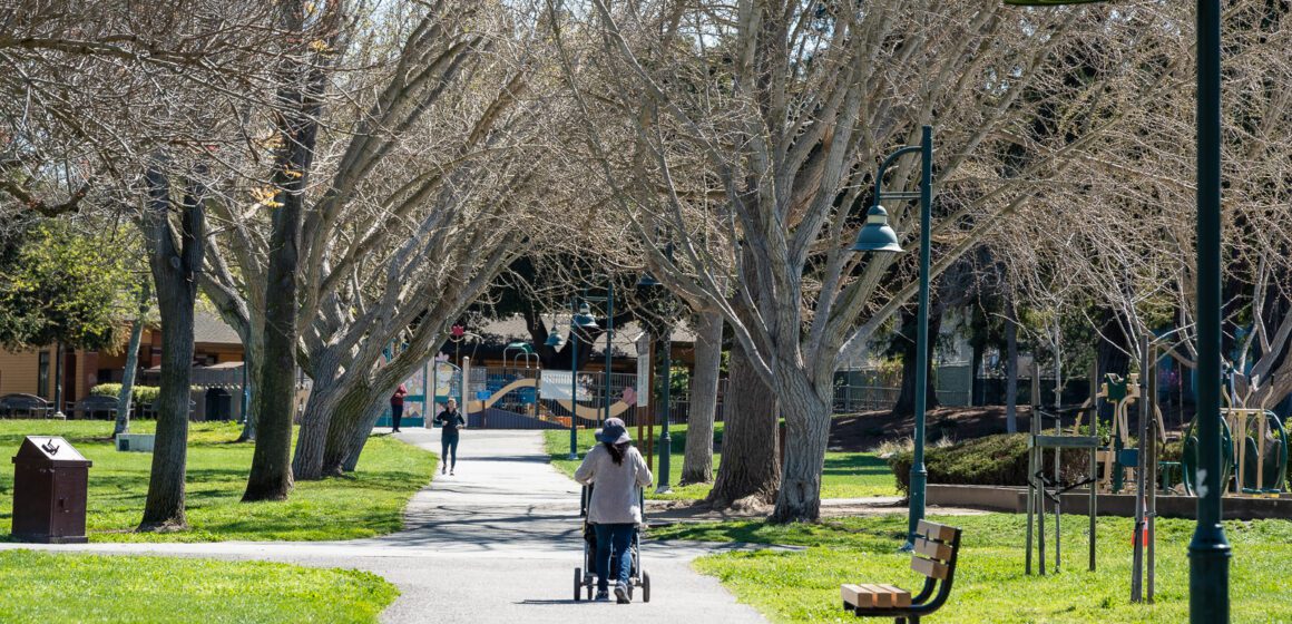 A person pushing a stroller on a path in a park in Mountain View, California
