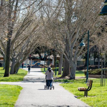 A person pushing a stroller on a path in a park in Mountain View, California