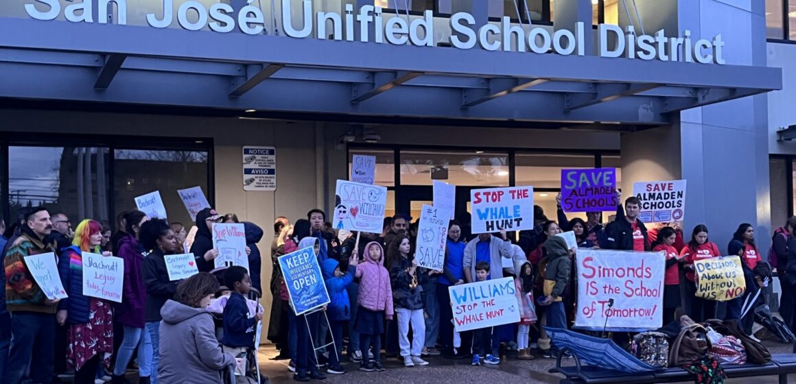 A group of people holding signs outside a school district office in San Jose, California