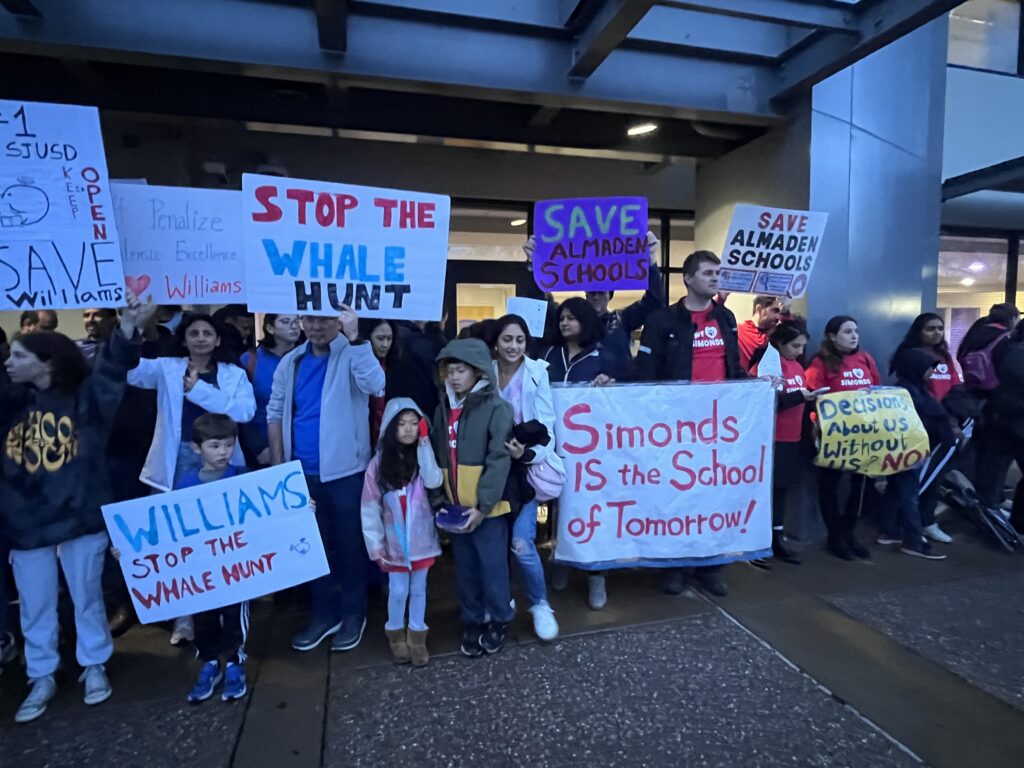 A group of people holding signs outside a school district office in San Jose, California