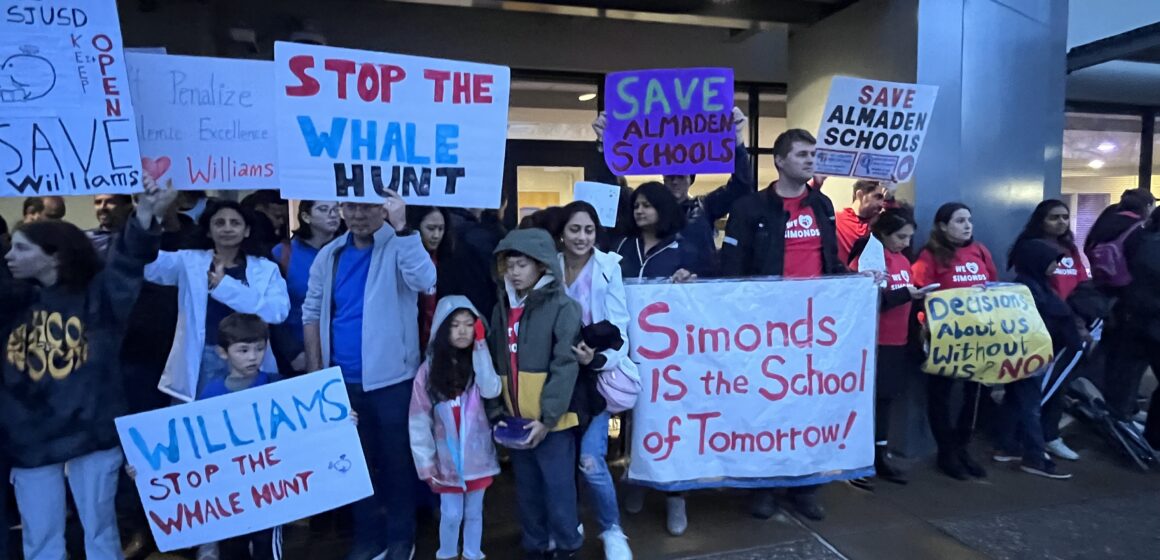 A group of people holding signs outside a school district office in San Jose, California