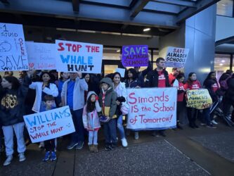 A group of people holding signs outside a school district office in San Jose, California