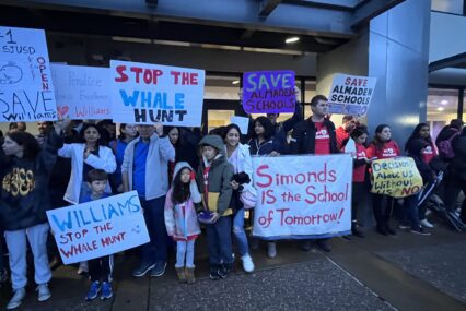 A group of people holding signs outside a school district office in San Jose, California
