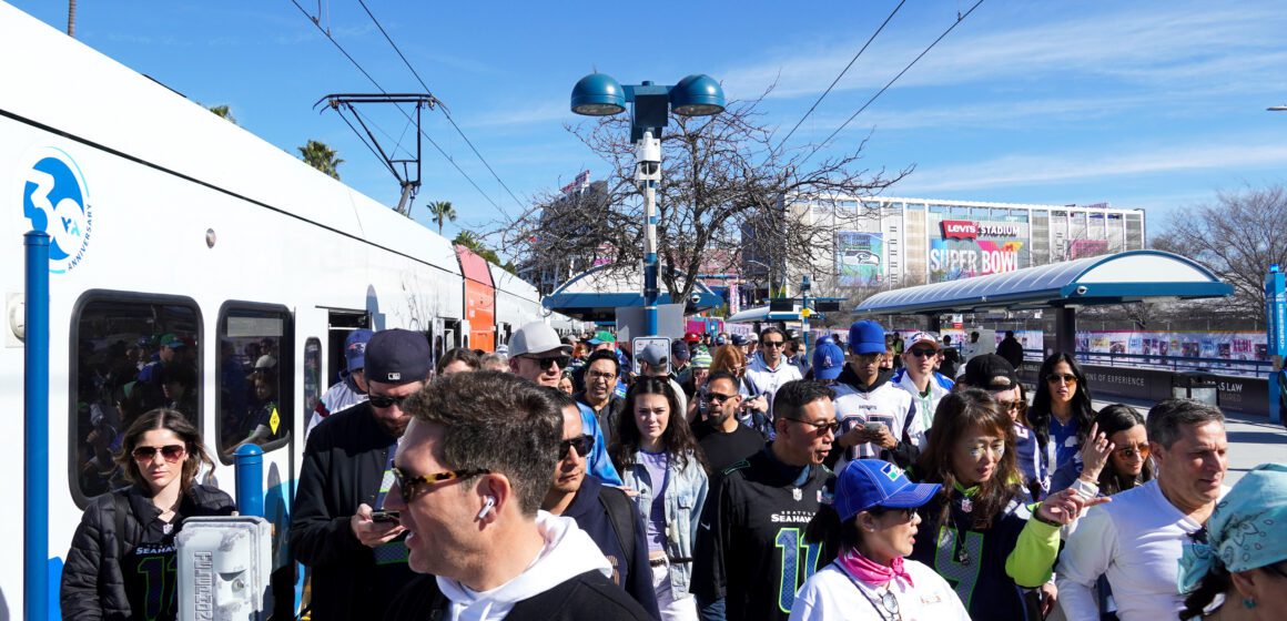 Una multitud de personas en una parada de transporte público en Santa Clara, California.
