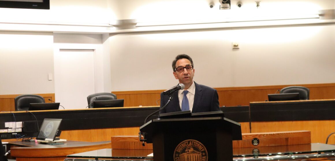 A man in a suit speaks at a podium at a government meeting in Santa Clara County, California