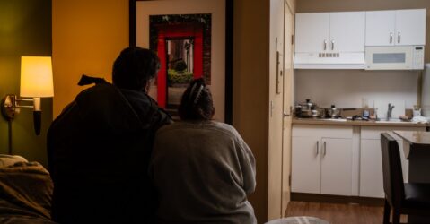 Two people sitting on a bed