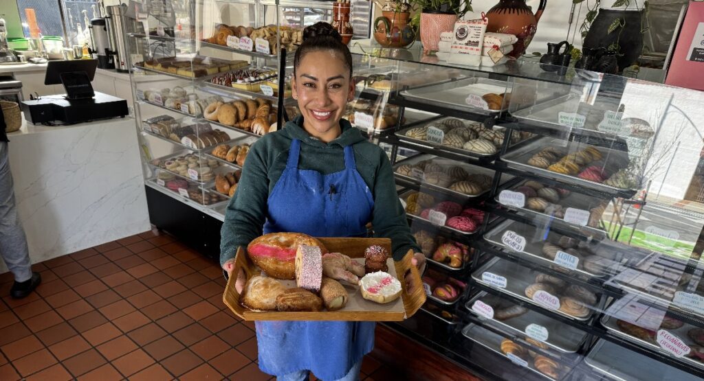 A woman holding a tray of Mexican sweet breads in San Jose, California
