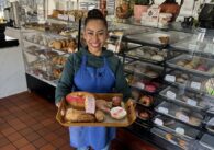 A woman holding a tray of Mexican sweet breads in San Jose, California