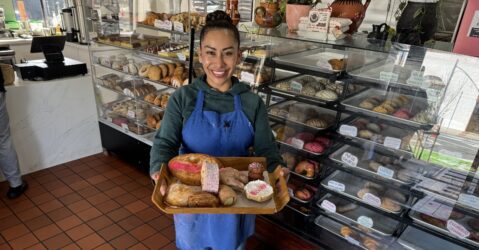 A woman holding a tray of Mexican sweet breads in San Jose, California